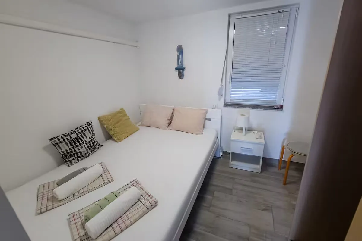 Single-bed bedroom with pink and cream pillows
