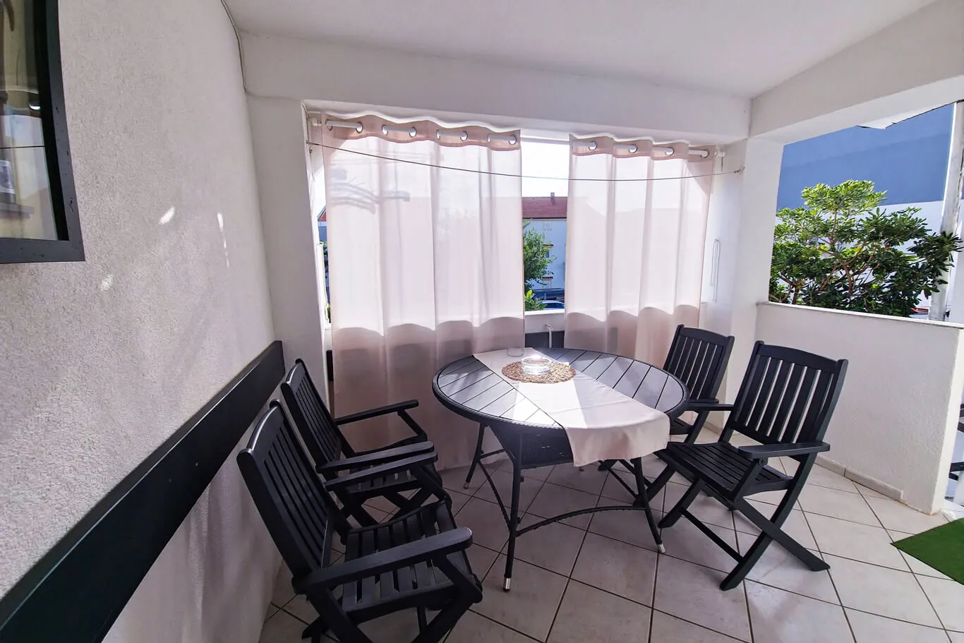 Balcony from a tighter angle, garden visible through the opening